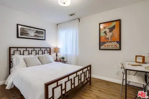 a bedroom with a bed and wooden floor