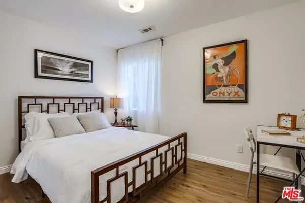 a bedroom with a bed and wooden floor