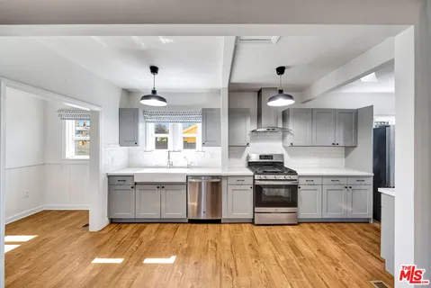 a large kitchen with stainless steel appliances granite countertop a stove and a sink