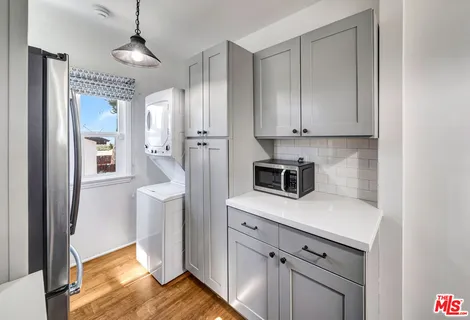 a kitchen with stainless steel appliances granite countertop a refrigerator a stove and white cabinets with wooden floor