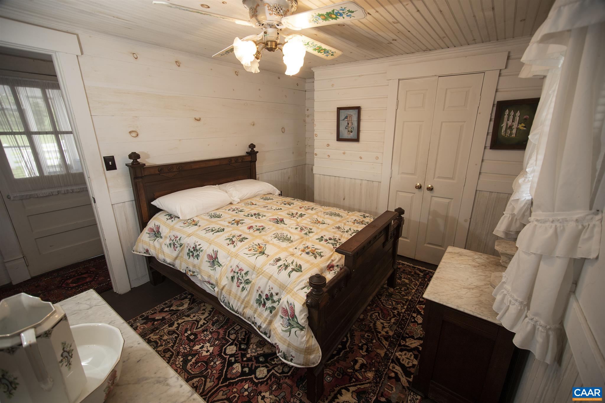 145 Turkey Way Amherst, VA 24521 - Photo 20 of 39 a bed sitting in a bedroom next to a window with a chandelier