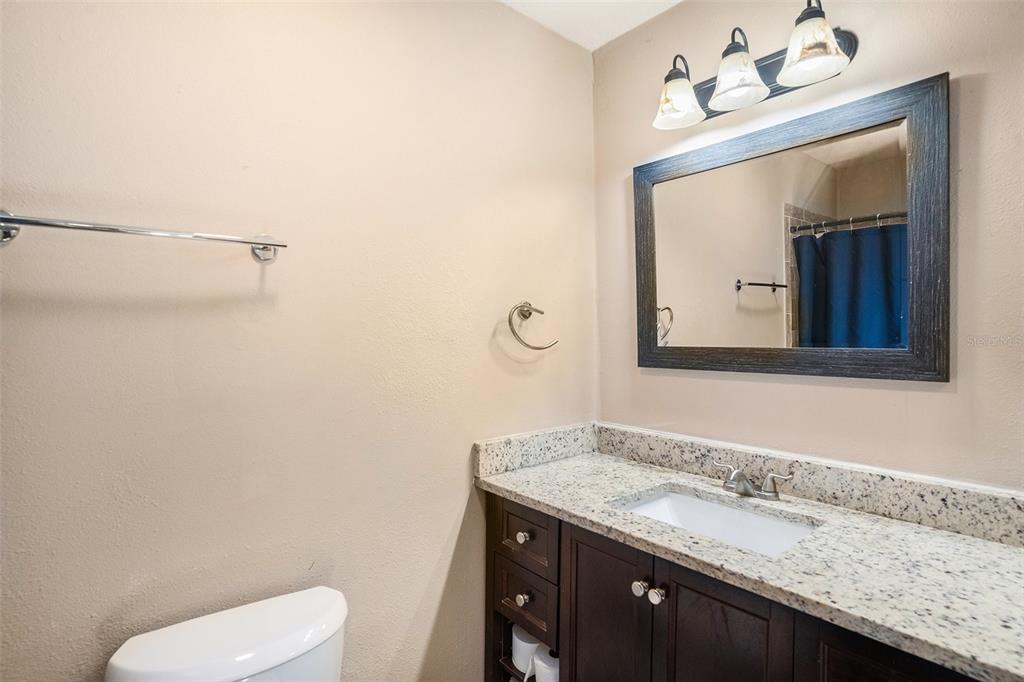 909 Silver Ridge Way Valrico, FL 33594 - Photo 9 of 15 a bathroom with a granite countertop sink a toilet and mirror