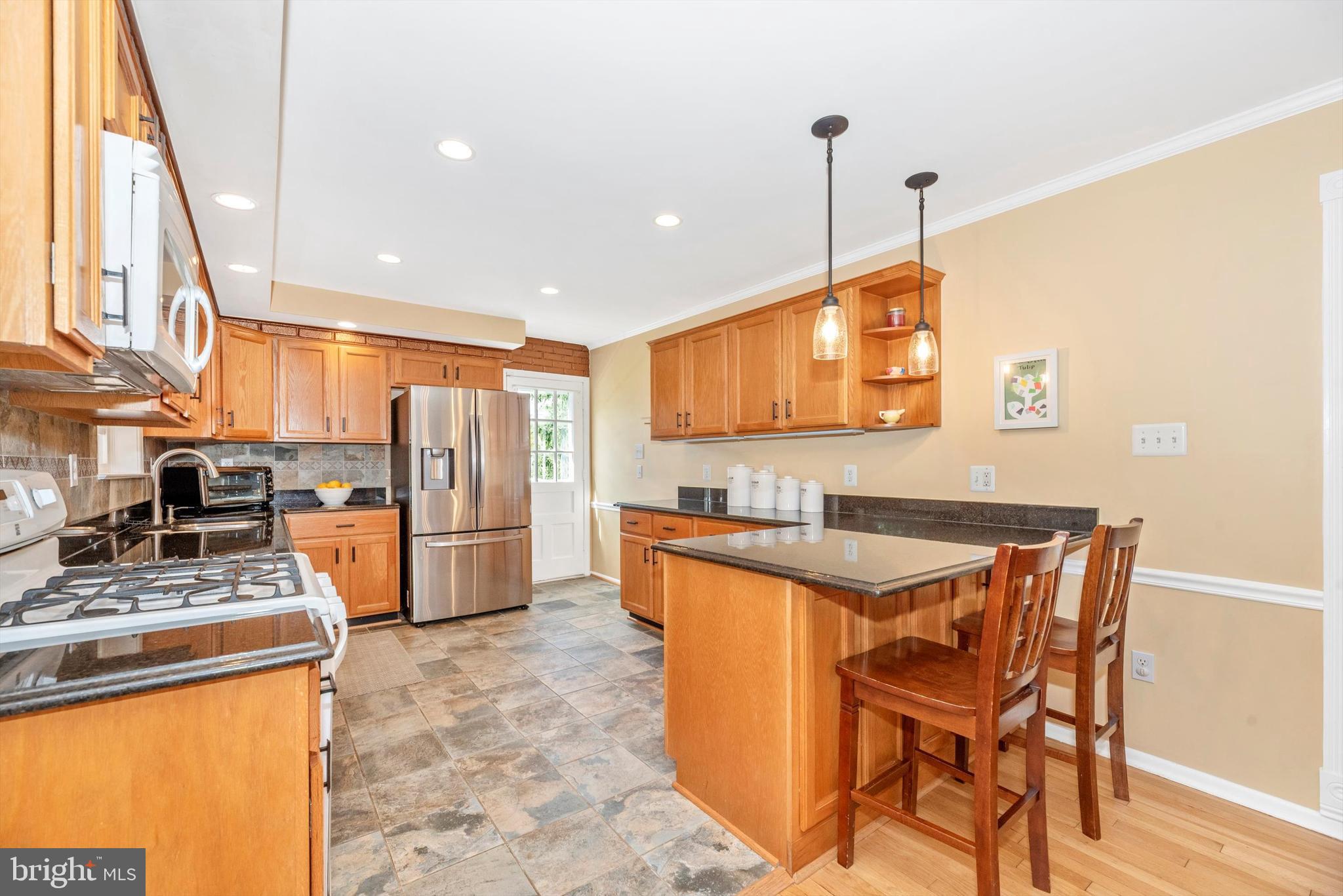 19605 Charline Manor Road Olney, MD 20832 - Photo 8 of 54 a kitchen with stainless steel appliances granite countertop a sink a stove a refrigerator cabinets dining table and chairs