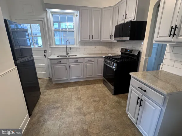 a kitchen with a sink stove and cabinets