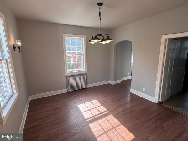 a view of empty room with wooden floor and window