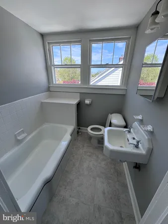 a bathroom with a tub sink and mirror