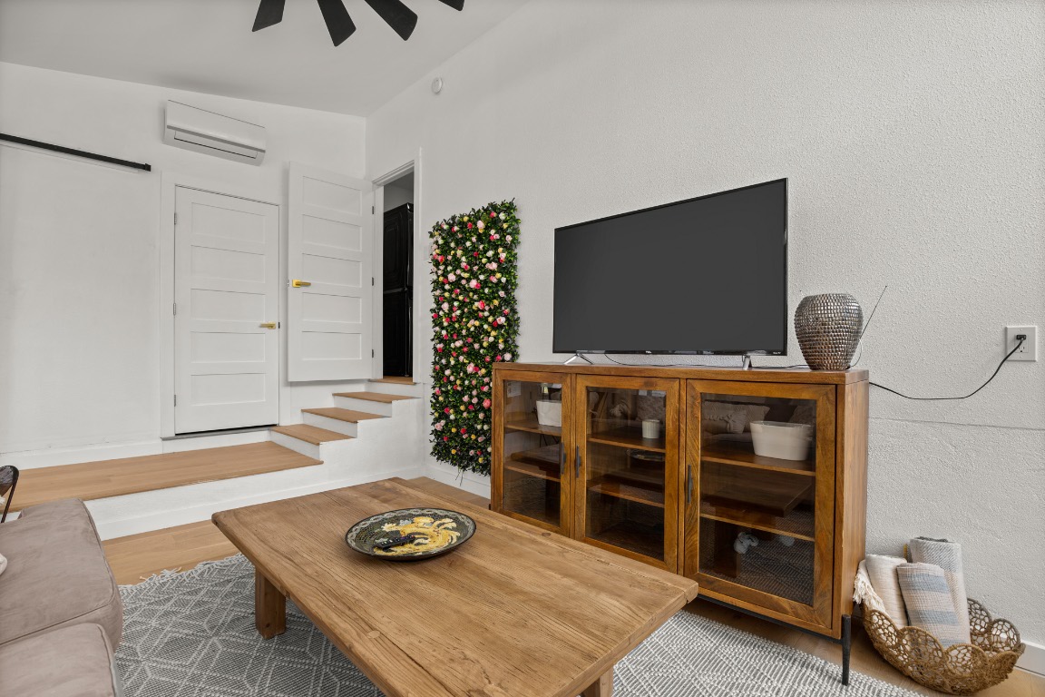 3904 Highland Drive Austin, TX 78734 - Photo 21 of 37 Living area with wood finished floors, a wall unit AC, and ceiling fan