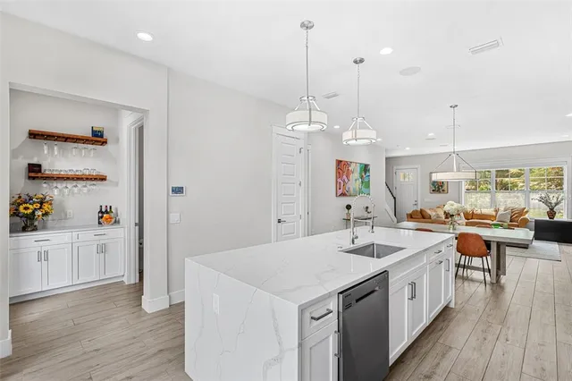 a kitchen with a sink stove and wooden floor