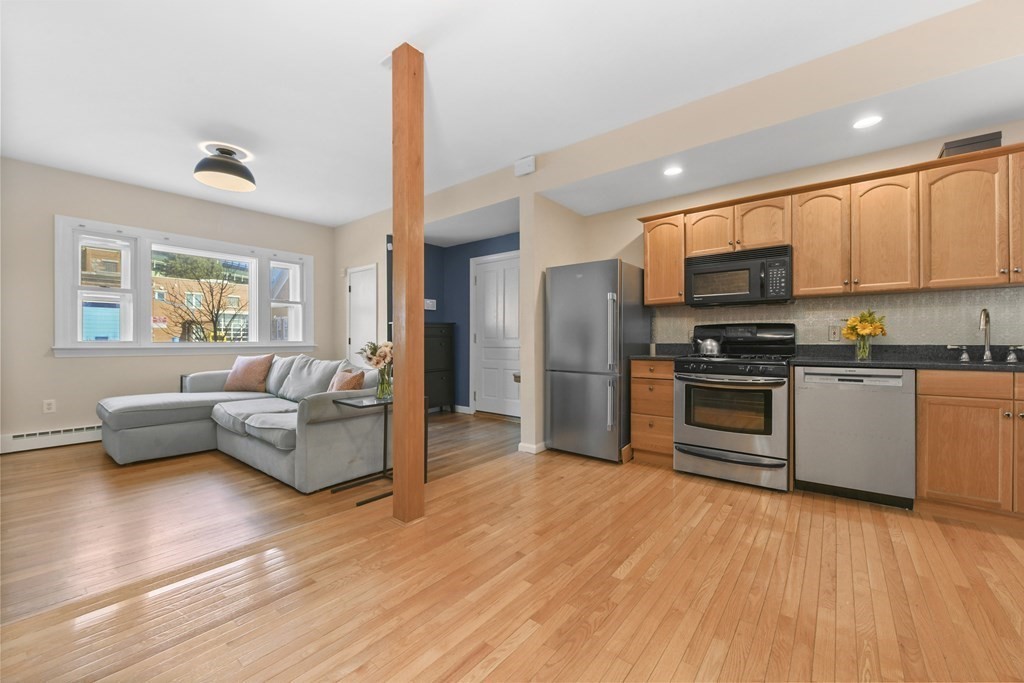 67 Broadway, Unit 1 Chelsea, MA 02150 - Photo 5 of 20 a kitchen with stainless steel appliances a refrigerator and wooden floor