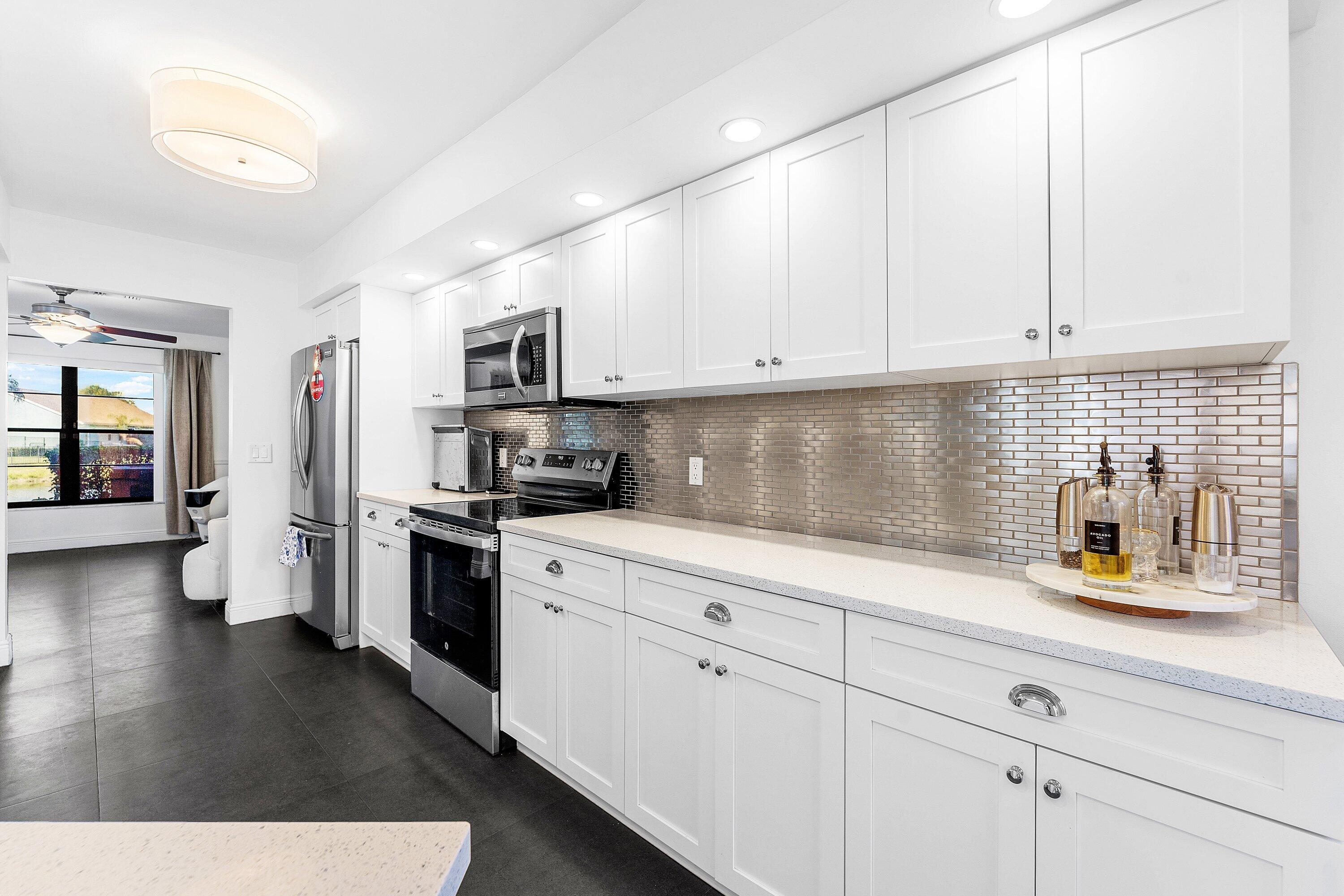 19931 Villa Lante Place Boca Raton, FL 33434 - Photo 12 of 47 a kitchen with granite countertop white cabinets and stainless steel appliances
