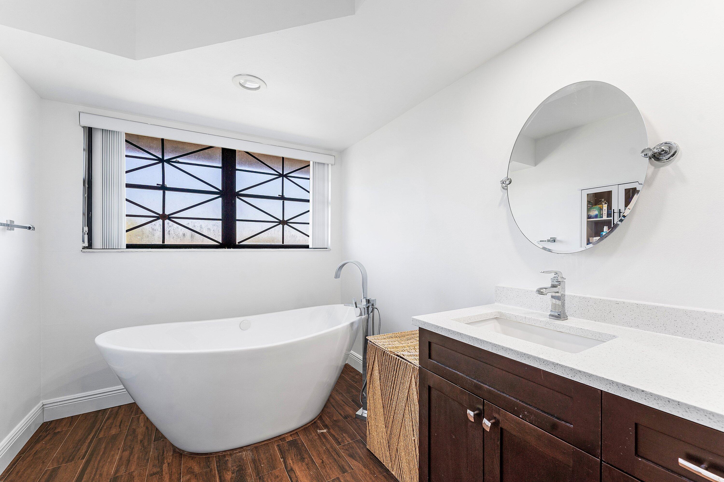 19931 Villa Lante Place Boca Raton, FL 33434 - Photo 28 of 47 a bathroom with a white tub a sink and mirror