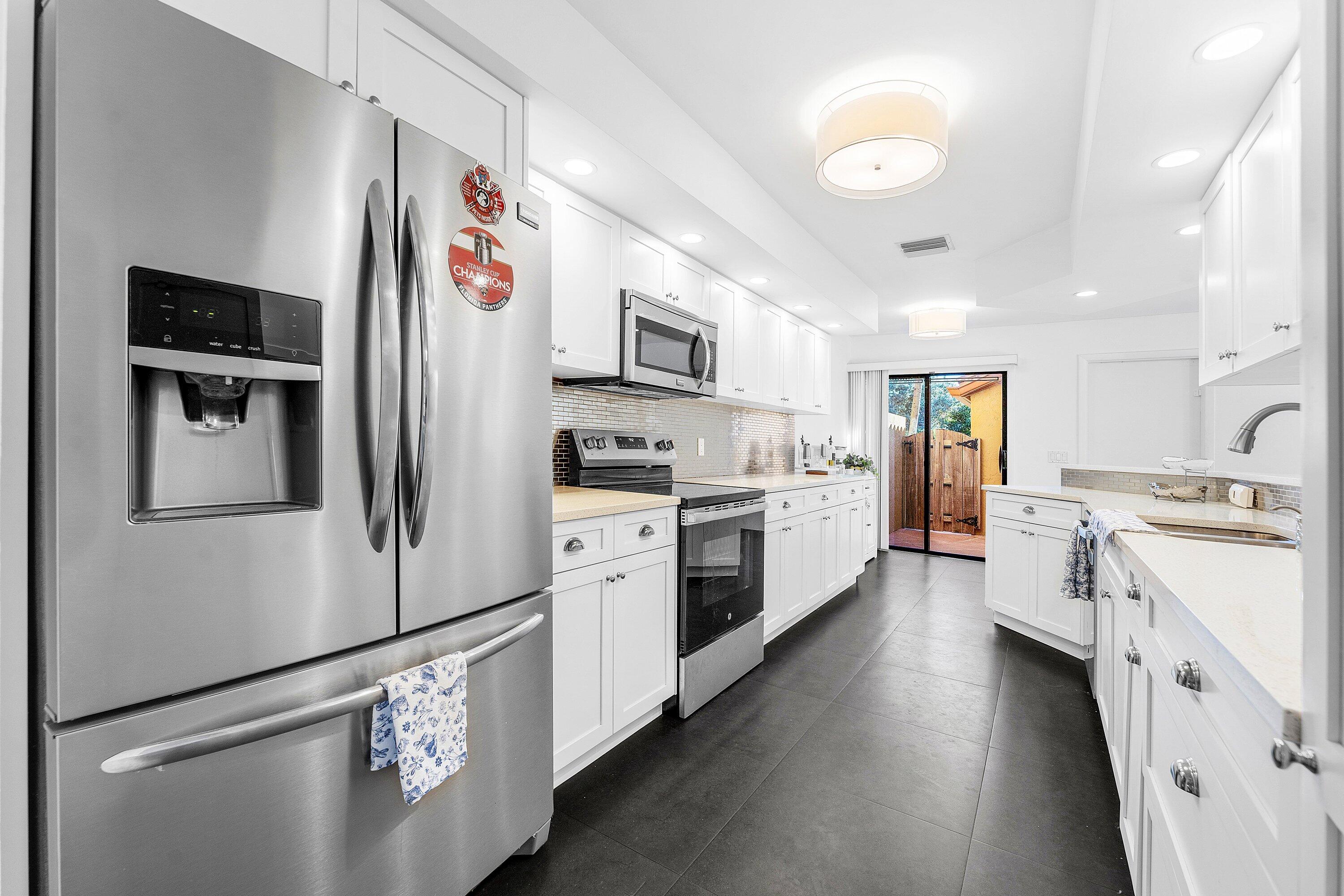 19931 Villa Lante Place Boca Raton, FL 33434 - Photo 10 of 47 a kitchen with stainless steel appliances and white cabinets