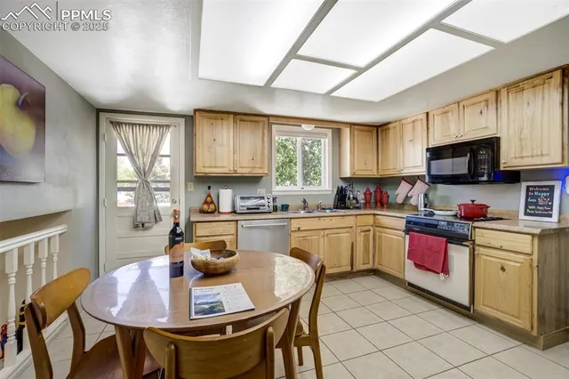 a kitchen with a stove a table and chairs in it