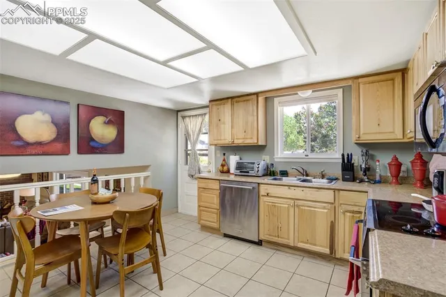 a kitchen with stainless steel appliances granite countertop a sink window and cabinets