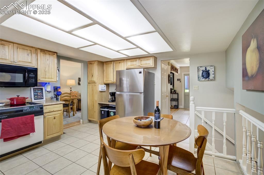 535 Silver Spring Circle Colorado Springs, CO 80919 - Photo 16 of 50 a kitchen with refrigerator cabinets dining table and chairs