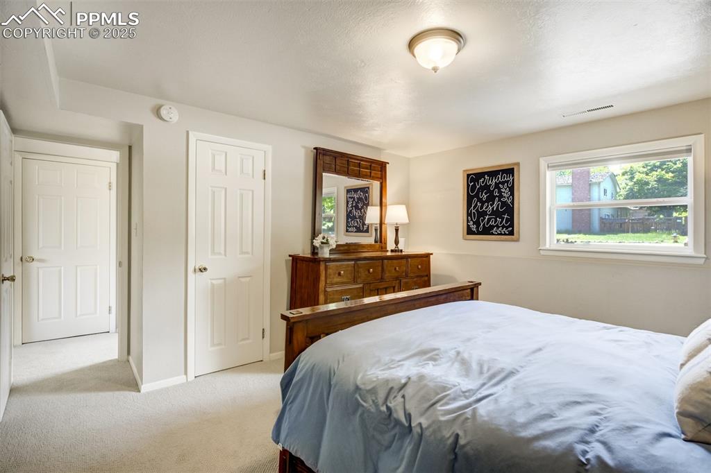 535 Silver Spring Circle Colorado Springs, CO 80919 - Photo 25 of 50 a bedroom with a bed and a dresser next to a window