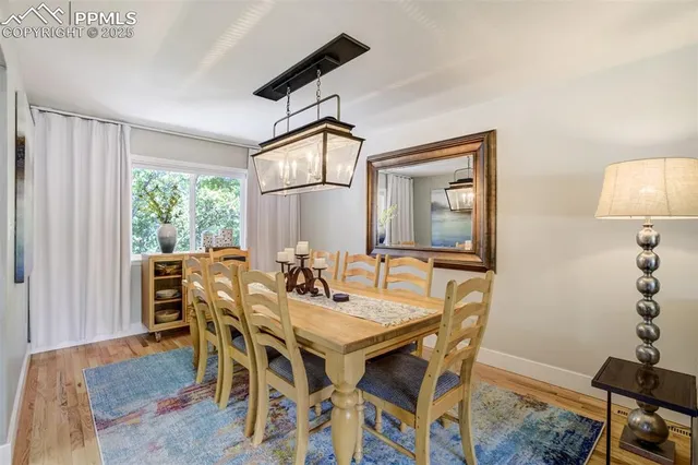 a living room with dining table and a large mirror on the table