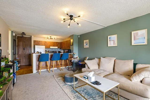 a living room with furniture kitchen view and a chandelier