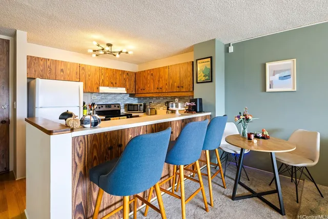 a kitchen with stainless steel appliances kitchen island a table chairs in it and a window