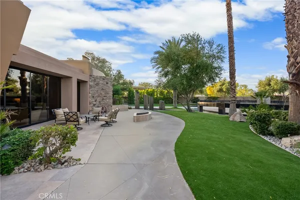 a view of a patio with couches and table and chairs with wooden fence