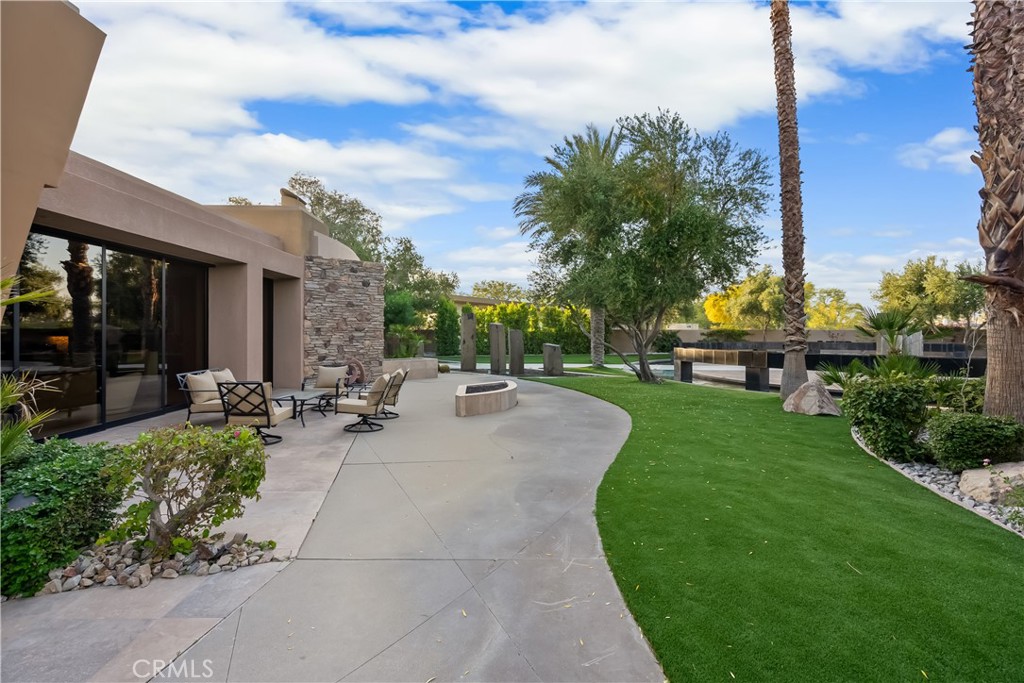 a view of a patio with couches and table and chairs with wooden fence