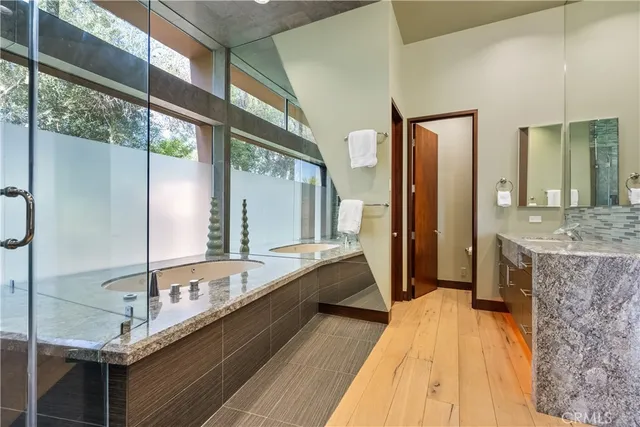 a bedroom with a bed large window and table