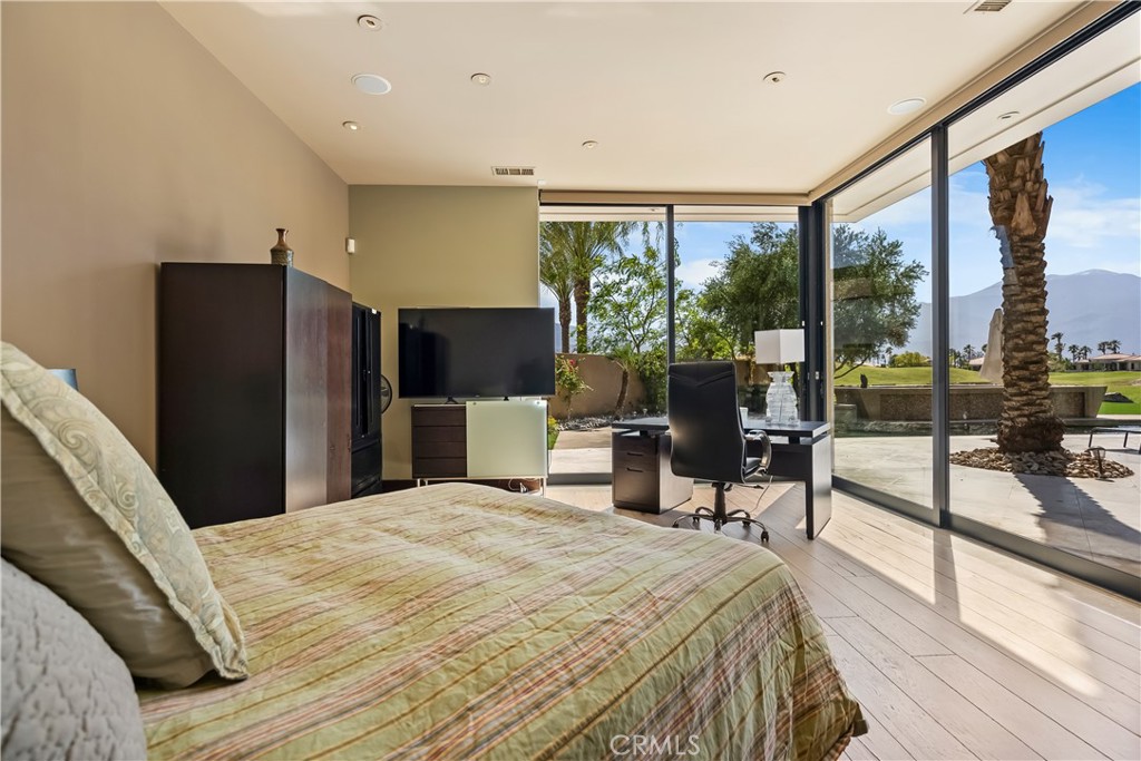 68 Royal St Georges Way Rancho Mirage, CA 92270 - Photo 28 of 73 a bedroom with a bed large window and table