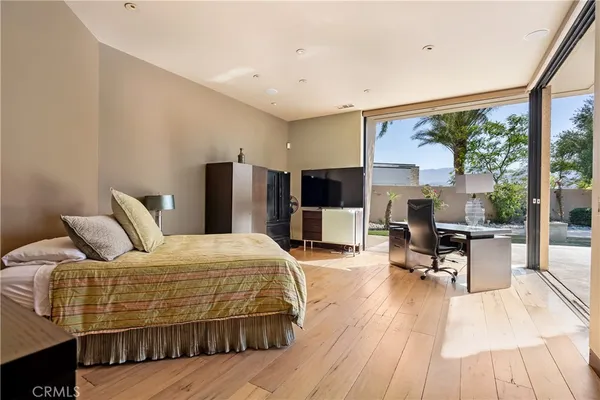 a bedroom with a bed and dresser with mirror