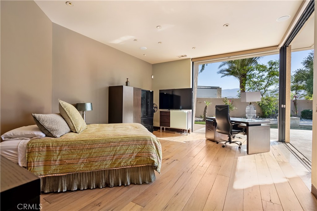 68 Royal St Georges Way Rancho Mirage, CA 92270 - Photo 30 of 73 a bedroom with a bed and wooden floor