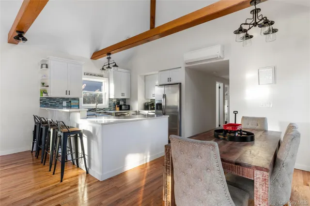 a kitchen with a dining table chairs and wooden floor