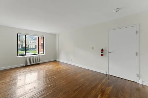 a view of an empty room with wooden floor