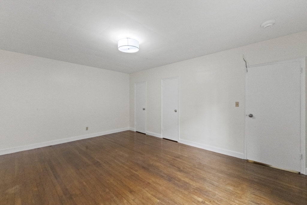 38-40 Cedar Street, Unit 335 Worcester, MA 01609 - Photo 17 of 21 an empty room with wooden floor and windows