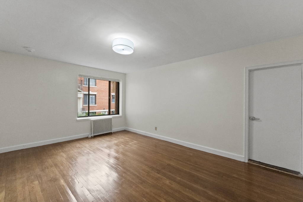38-40 Cedar Street, Unit 335 Worcester, MA 01609 - Photo 19 of 21 an empty room with wooden floor and windows