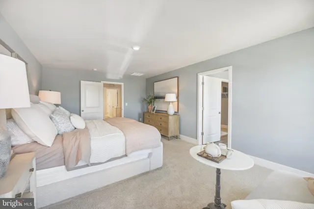 a bedroom with a bed chandelier and a dining table