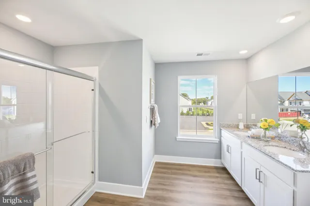 a bathroom with a granite countertop sink a toilet and a shower