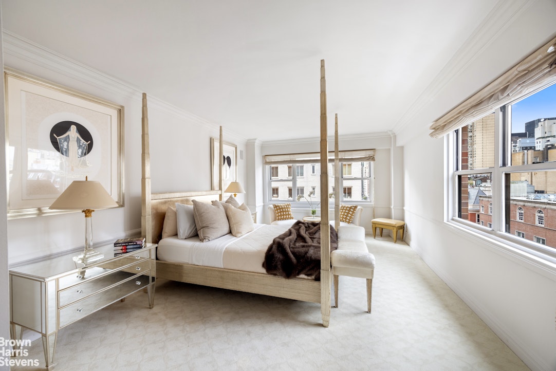 27 East 65th Street, Unit 9DE Manhattan, NY 10065 - Photo 6 of 14 a spacious bedroom with a bed a lamp and large windows