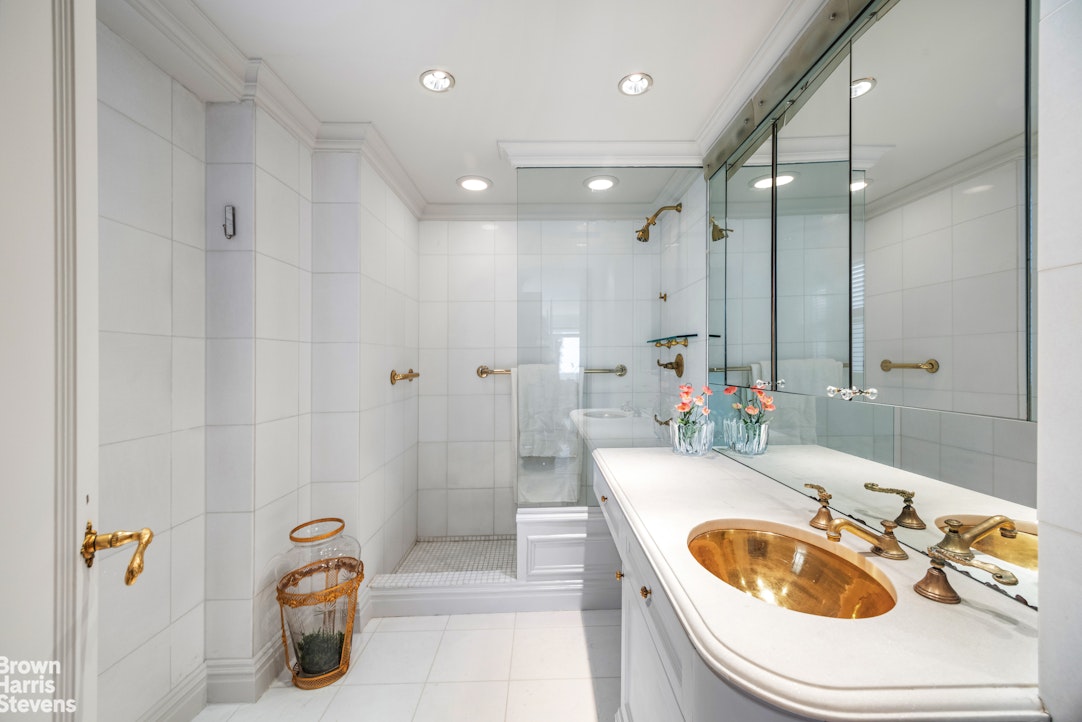 27 East 65th Street, Unit 9DE Manhattan, NY 10065 - Photo 7 of 14 a bathroom with a tub sink toilet and mirror