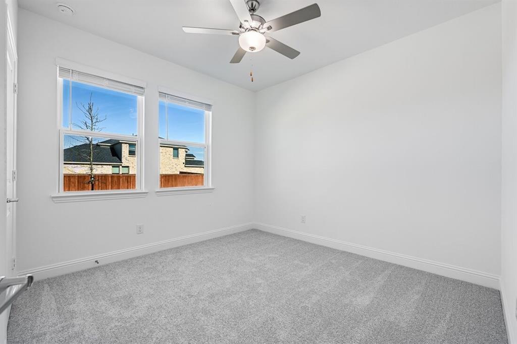 1429 Arciones Road Fort Worth, TX 76052 - Photo 18 of 39 an empty room with chandelier fan and windows