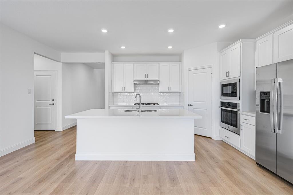 1429 Arciones Road Fort Worth, TX 76052 - Photo 2 of 39 a large kitchen with stainless steel appliances a large counter top a stove and a refrigerator