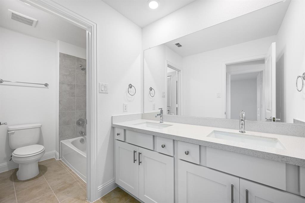 1429 Arciones Road Fort Worth, TX 76052 - Photo 22 of 39 a spacious bathroom with a granite countertop sink a toilet and a mirror
