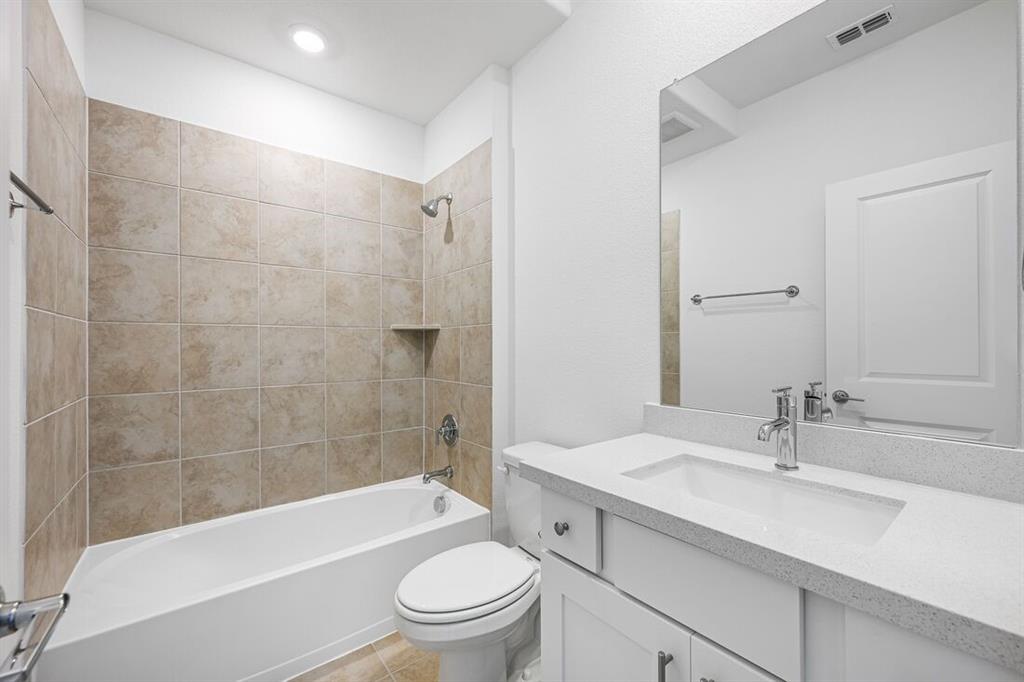 1429 Arciones Road Fort Worth, TX 76052 - Photo 23 of 39 a bathroom with a granite countertop bathtub shower sink mirror vanity and toilet