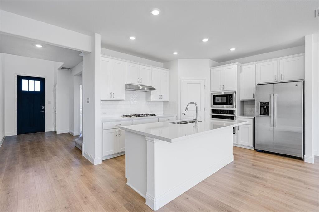 1429 Arciones Road Fort Worth, TX 76052 - Photo 3 of 39 a kitchen with white cabinets and stainless steel appliances