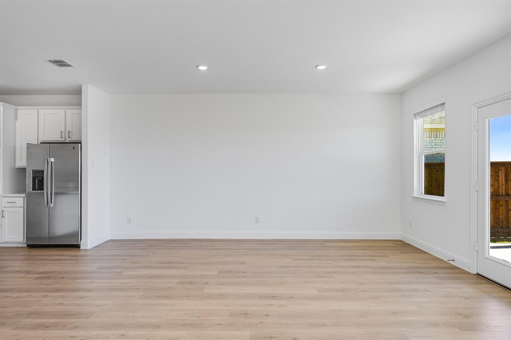 1429 Arciones Road Fort Worth, TX 76052 - Photo 8 of 39 a view of an empty room with wooden floor and a window