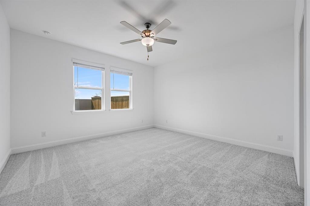 1429 Arciones Road Fort Worth, TX 76052 - Photo 10 of 39 an empty room with chandelier fan and windows