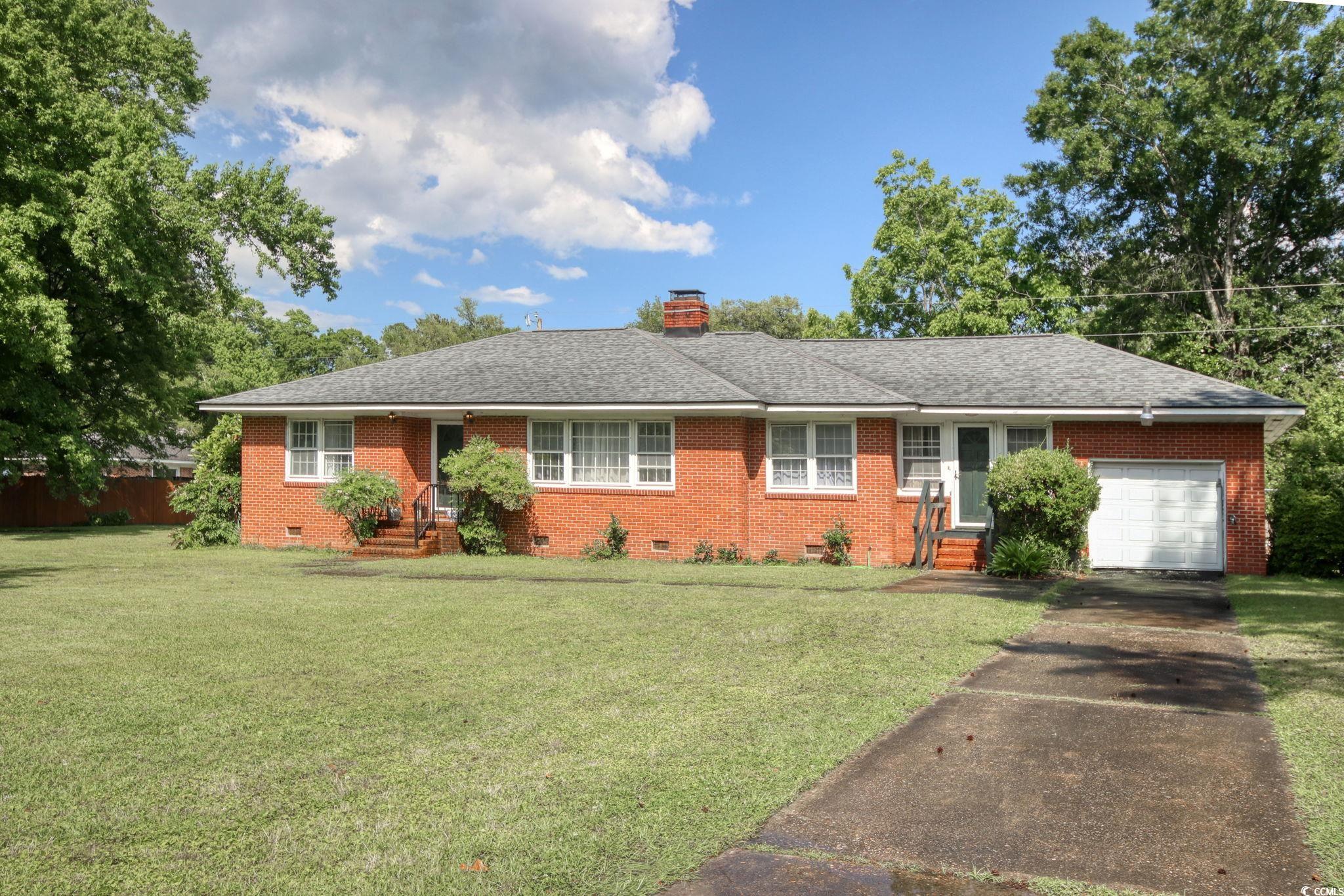 Single story home featuring crawl space, a garage, brick siding, and asphalt driveway