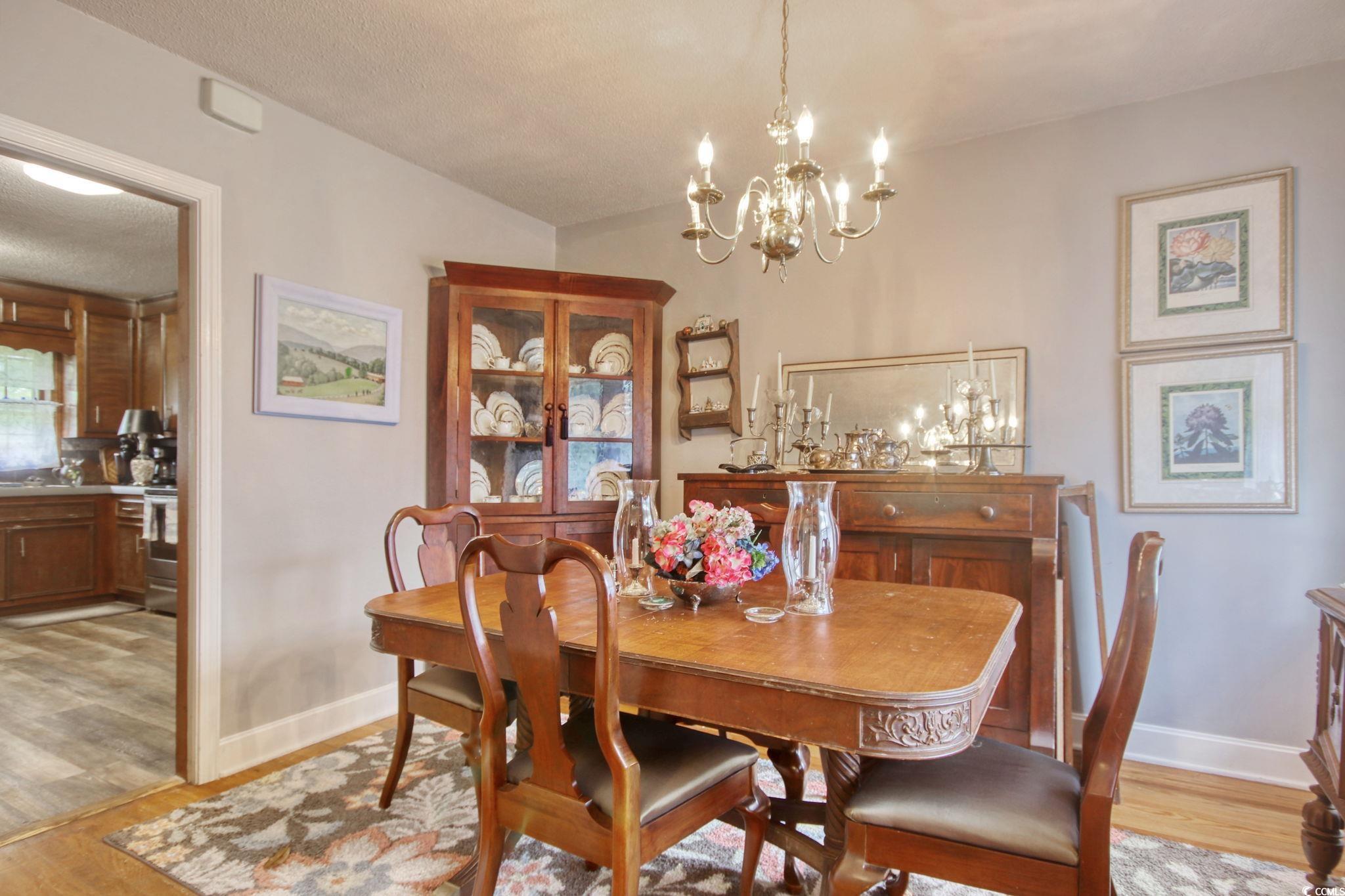 2004 Seitter Street Georgetown, SC 29440 - Photo 12 of 33 Dining room with light wood-style floors, a chandelier, and baseboards