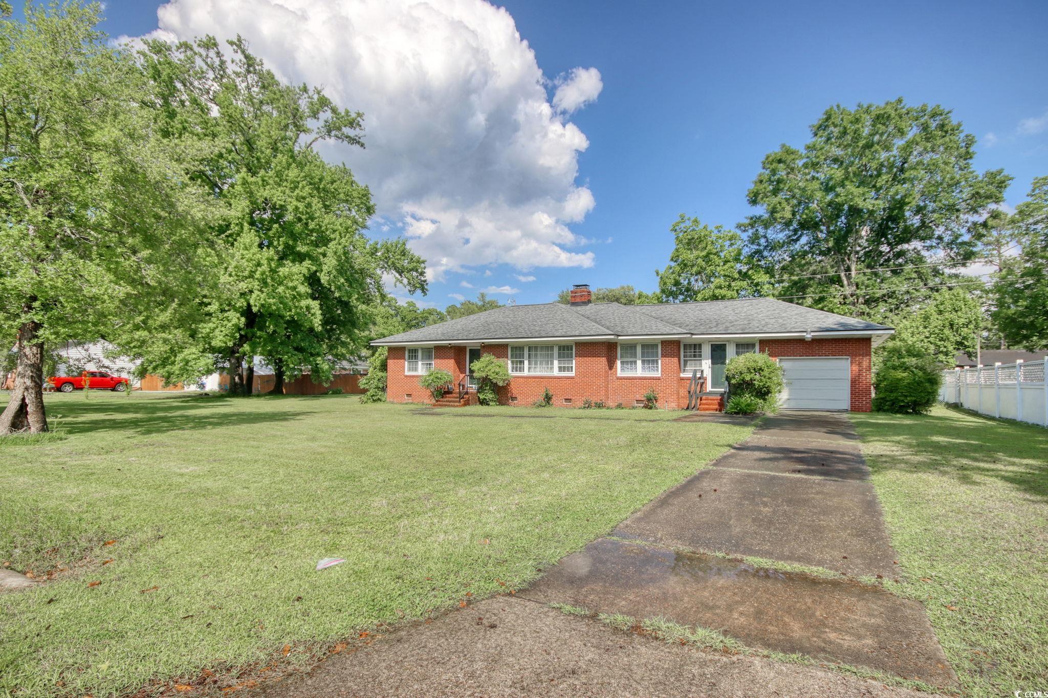 2004 Seitter Street Georgetown, SC 29440 - Photo 4 of 33 Ranch-style house featuring brick siding, a garage, a chimney, and driveway