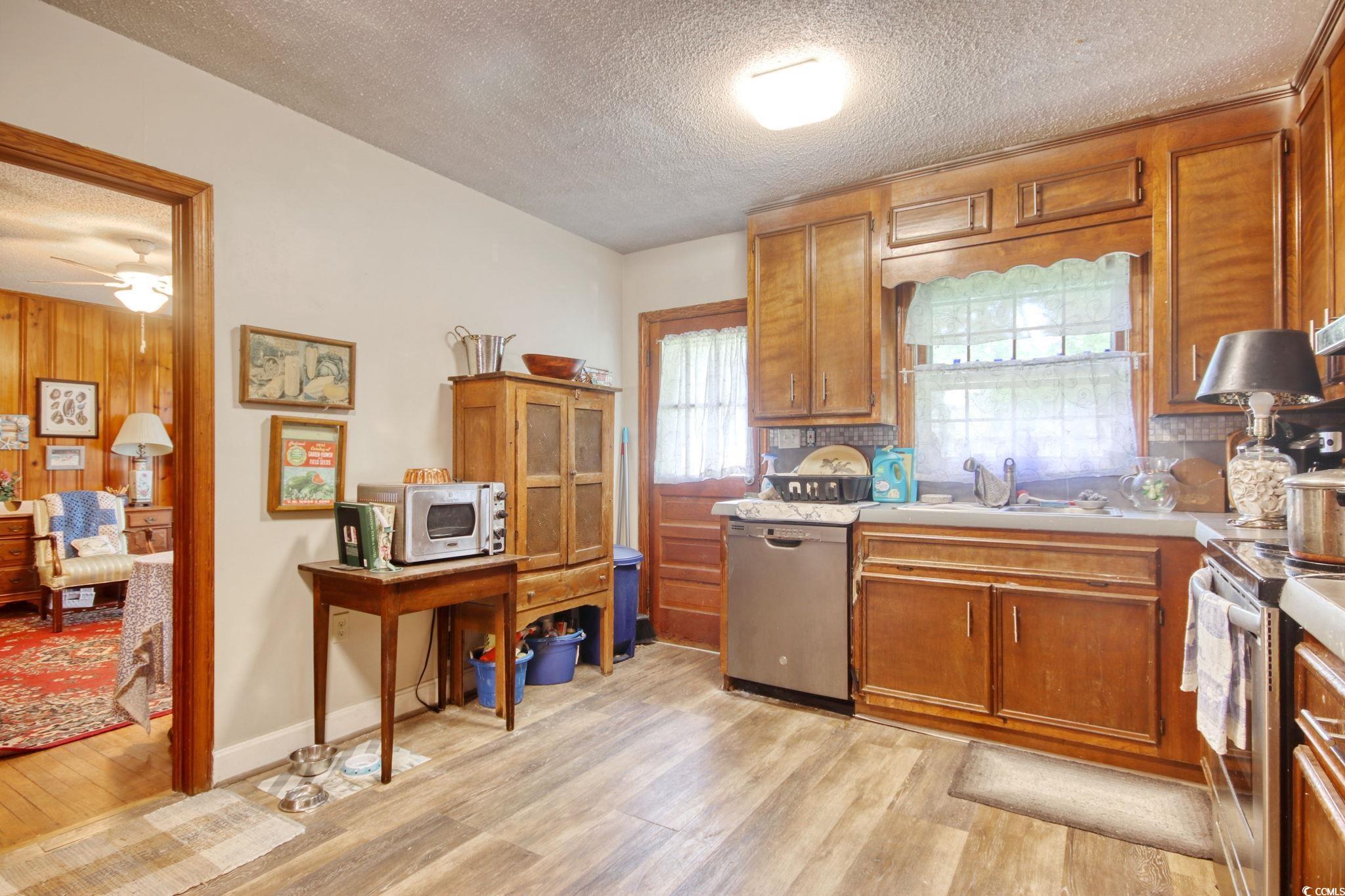 2004 Seitter Street Georgetown, SC 29440 - Photo 8 of 33 Kitchen featuring stainless steel appliances, a textured ceiling, light wood-style flooring, light countertops, and brown cabinetry