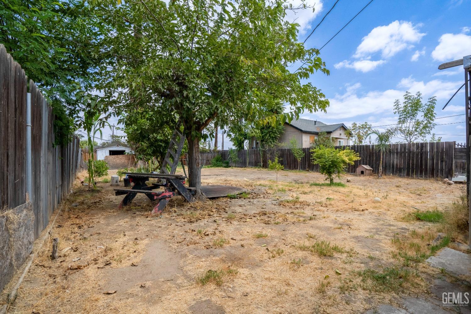 Undisclosed Address Bakersfield, CA 93305 - Photo 19 of 23 a view of backyard with table and chairs and a large tree