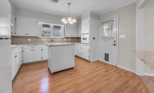 a spacious bathroom with a granite countertop sink a mirror and a bathtub